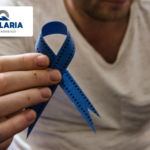 Hombre sosteniendo un lazo azul en apoyo a la concientización de la salud masculina.